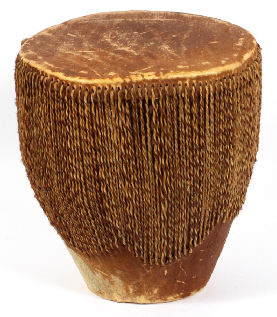 TOM-TOM DEER HIDE DRUM, H 15'', DIA 13'': TOM-TOM DEER HIDE DRUM, H 15'', DIA 13''HAVING A LARGE DIAMETER AT THE TOP NARROWING DOWN TO A SMALLER DIAMETER AT THE bottom. INDIVIDUAL RAWHIDE STRIPS STRETCH THE DEER HIDE SKIN TAUT.