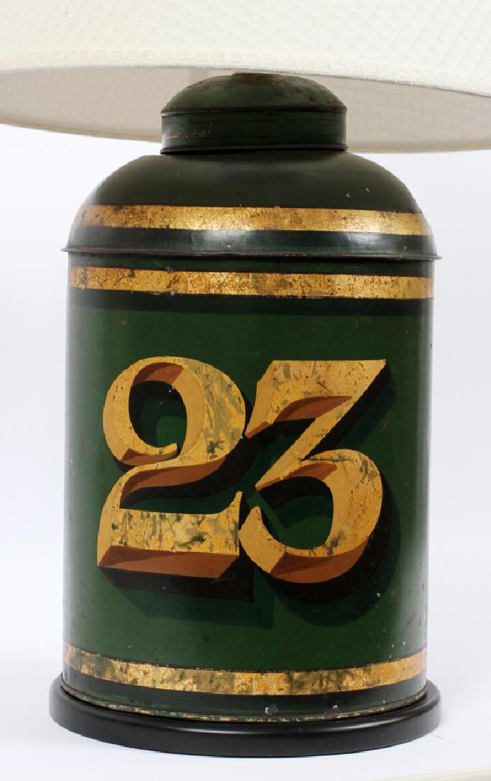 PAINTED TOLE TIN CANISTER LAMP, H 29", DIA 18": PAINTED TOLE TIN CANISTER LAMP, H 29", DIA 18" :A painted Tole Tin lamp with the number "23". The canister was originally used to store tea in food shops, before the invention of individual tea bags. 