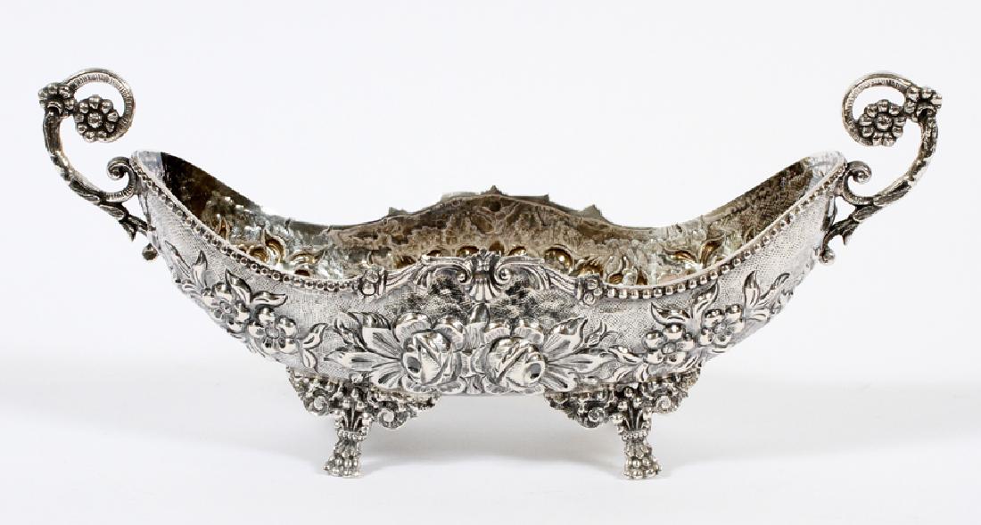 ROCOCO STYLE 800 STERLING SILVER SERVING DISH: ROCOCO STYLE, 800 STERLING SILVER SERVING DISH, H 5 1/4", W 12â€ W, D 4â€ D :A Rococo style sterling silver serving dish. Features an elaborate floral motif, flanked by two symmetrical scroll fo