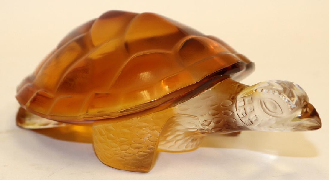 LALIQUE CRYSTAL SCULPTURE TURTLE: LALIQUE CRYSTAL SCULPTURE, H 1 3/4", W 3 1/2", D 5 3/4", TURTLE :A Lalique carved crystal sculpture. This piece depicts a turtle with its head out of its amber-colored shell. The artist's signature is