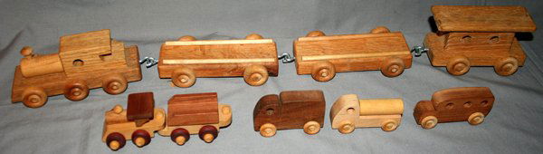 TOY WOOD TRAIN SET & TRUCKS, C.1960, 10 PCS.: TOY WOOD TRAIN SET AND TRUCKS, C 1960, 10 PCS., H 2"-3", L 3"-7":includes larger train set with engine, 3 flat cars (one not shown in photo) and caboose; small engine and tender; and 3 small trucks.