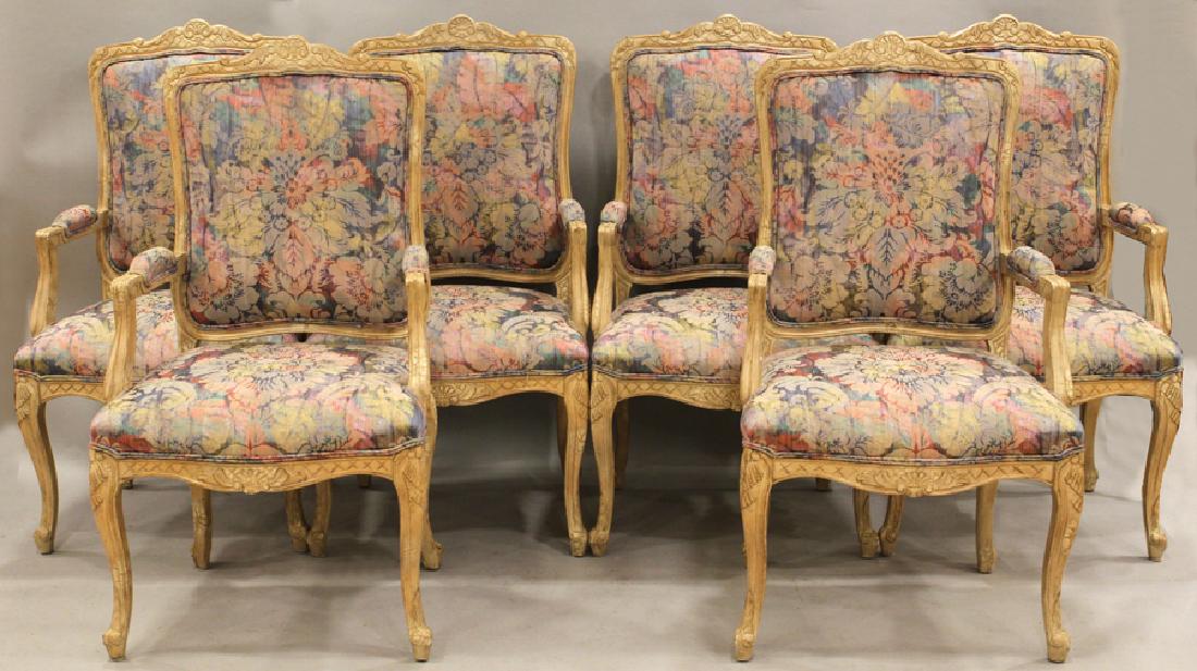 FRENCH STYLE UPHOLSTERED ARM CHAIRS, SIX: FRENCH STYLE UPHOLSTERED ARM CHAIRS, SIX, H 43.75", W 23" Each having carved blonde wood frames with carved crests and floral upholstered seats, backs and arm pads.