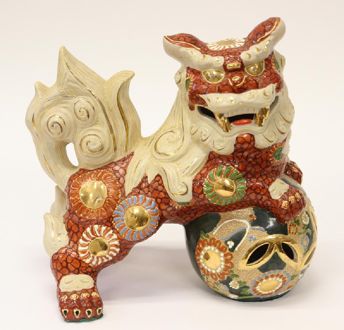 MULTI-COLORED, PORCELAIN FOO DOG: MULTI-COLORED, PORCELAIN FOO DOG, H 10", W 10", D 5" Having an ivory color mane and tail, red body with multi-colored medallions. Front paws on a green and pierced design ball also with various color