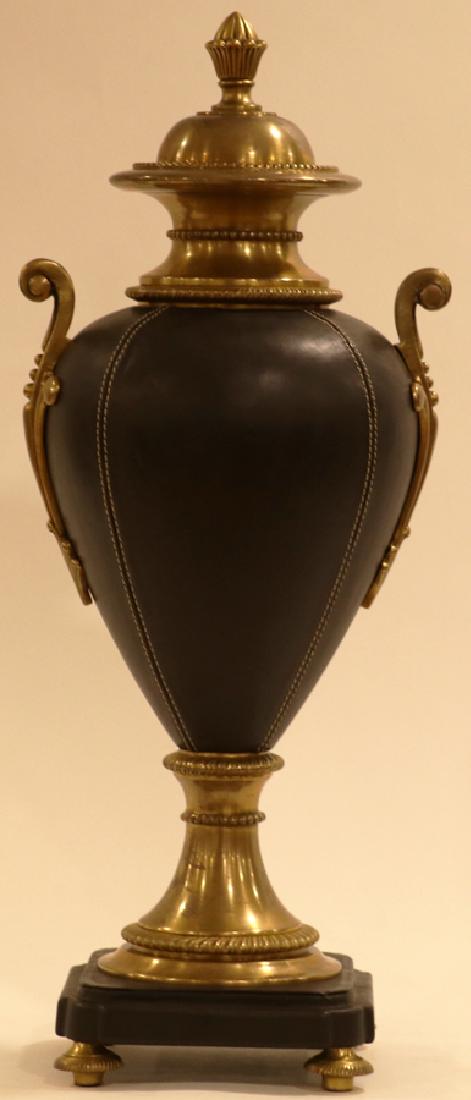 MAITLAND SMITH, BLACK LEATHER CLAD AND BRASS URN: MAITLAND SMITH, BLACK LEATHER CLAD AND BRASS URN WITH LID, H 18", DIA 8" :Having a brass lid with finial. Brass neck mounted to a white metal body clad in stitched black leather with bronze ormolu han
