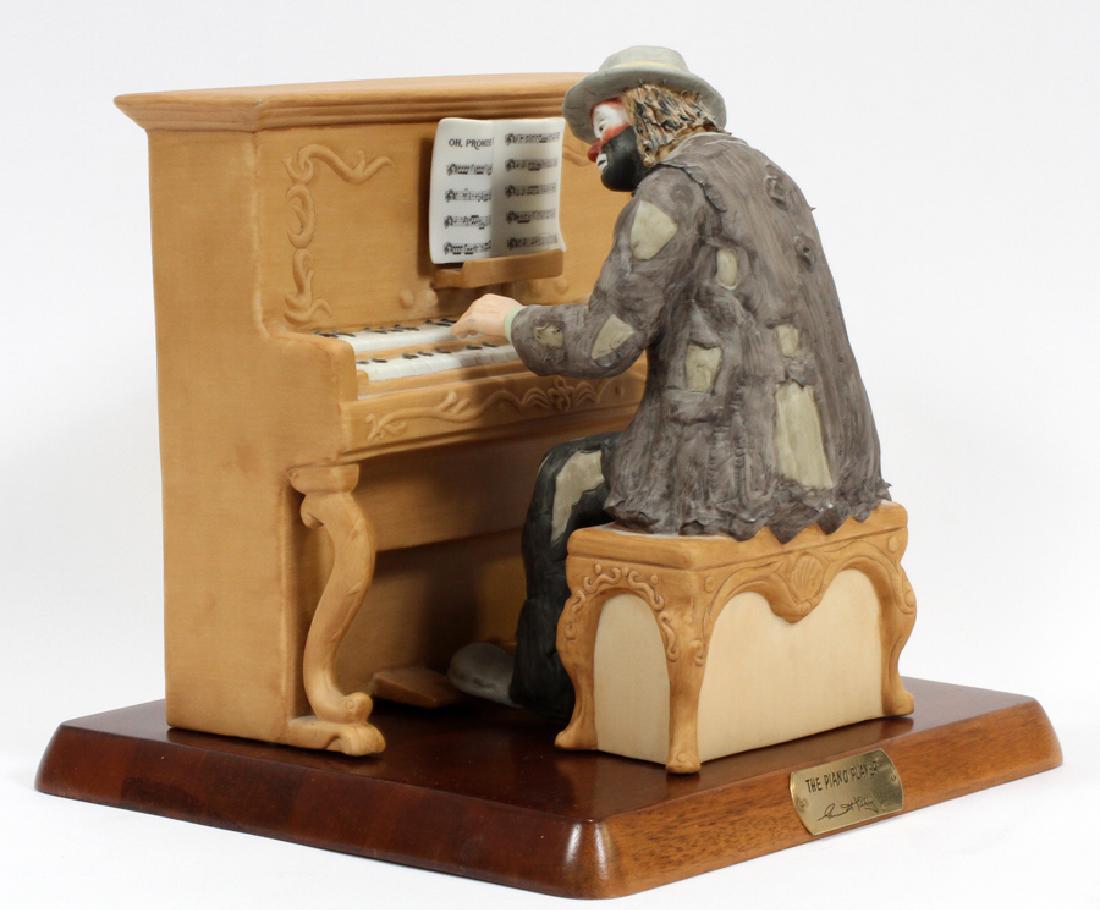 EMMETT KELLY JR. FIGURINE"THE PIANO PLAYER": EMMETT KELLY JR. FIGURINE, 3 PCS, H 9", W 10", D 9 3/4", "THE PIANO PLAYER" :A collectible bisque porcelain figurine in the Emmett Kelly Jr. Signature Line, featuring Kellyâ€™s beloved tragicomic