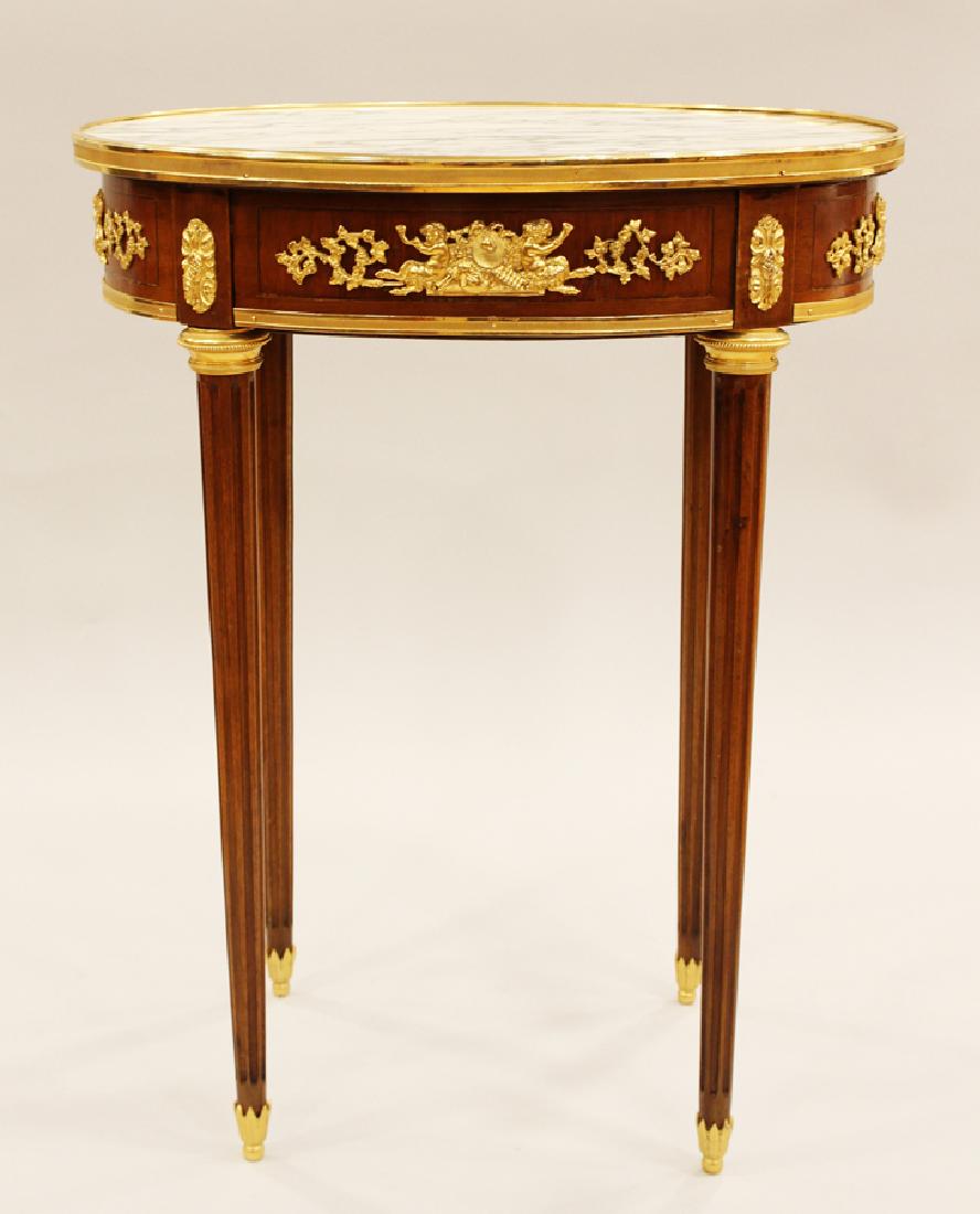 LOUIS XVI STYLE MARBLE TOP TABLE W/ BRONZE ORMOLU: LOUIS XVI STYLE, OVAL MARBLE TOP TABLE WITH BRONZE ORMOLU, H 29 1/2", W 23 3/4", D 17 3/4" :Having a marble top and ormolu mounts. Having fluted legs.