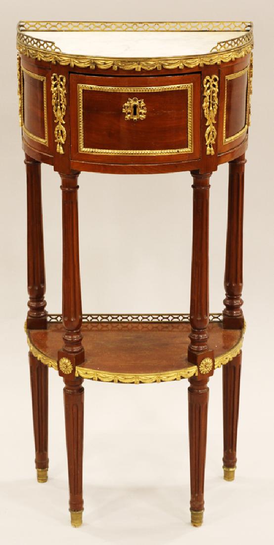 LOUIS XVI STYLE INSET MARBLE TOP SIDE TABLE: LOUIS XVI STYLE, DEMI LUNE, INSET MARBLE TOP, TWO TIER SIDE TABLE, H 35 1/2", W 16 1/4", D 10":Mahogany having a single drawer with lock and key and featuring a marble top with bronze gallery and ormo