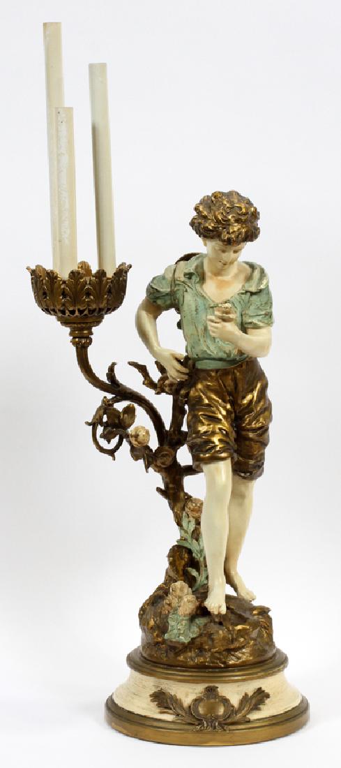 AFTER L. F. MOREAU FIGURAL LAMP, 20TH C.: AFTER L. F. MOREAU FIGURAL LAMP, 20TH C., H 38", W 12", D 10":A table lamp after Art Nouveau artist L. F. Moreau. This hand-painted piece features a young boy grasping flower next two a rose bush that