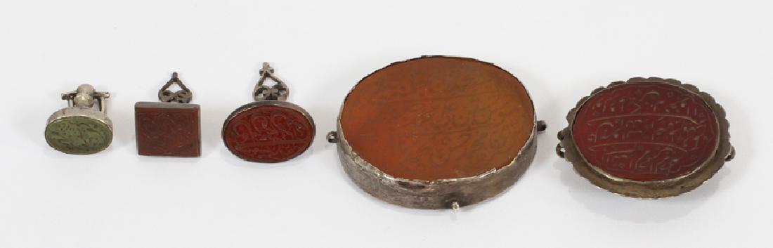 ANCIENT PERSIAN CARNELIAN & AGATE SIGNETS, 5 PCS: ANCIENT PERSIAN CARNELIAN & AGATE SIGNETS, 5 PCS, DIA .75-1.5" :A rare grouping of ancient Persian signets, possibly from the 11th century. The pieces feature intaglios in carnelian and green agate, a