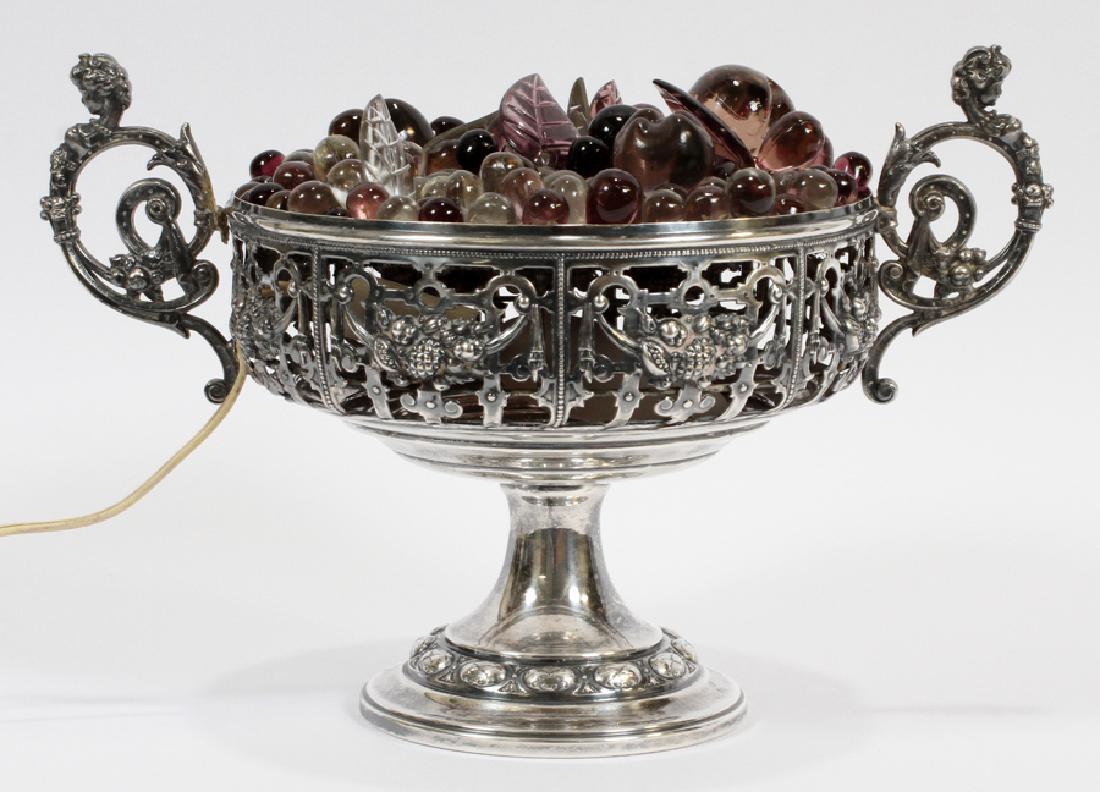 FRUIT BASKET FORM, GLASS AND SILVER PLATE LAMP: FRUIT BASKET FORM, GLASS AND SILVER PLATE LAMP, H 7", DIA 13" :Glass faux fruit in pierced silver plate bowl. Electrified.One handle has become detached at the top.