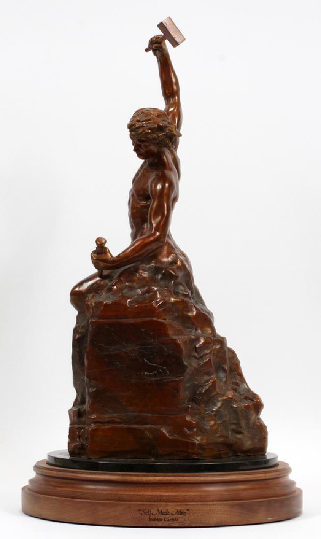 BOBBIE K. CARLYLE, LOVELAND, CO. BRONZE SCULPTURE: BOBBIE K. CARLYLE, LOVELAND, CO. BRONZE SCULPTURE, 1996 H 24" "SELF MADE MAN" :Signed and dated. #264/650. On wood swivel base. "Self Made Man" is a figure of a "man carving himself out of stone, carv