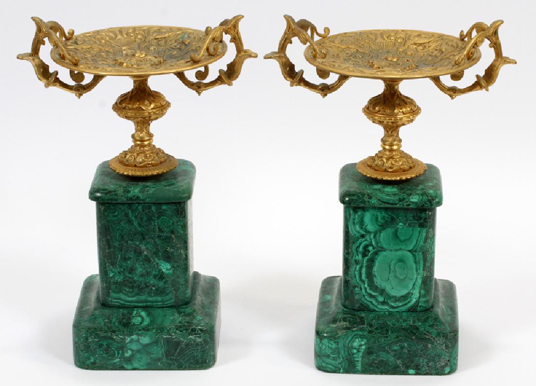 BRONZE & MALACHITE TAZZAS, PAIR H 12", L 7 3/4": BRONZE & MALACHITE TAZZAS, PAIR H 12", L 7 3/4" :Double handles with urn and scrolling leaf design with bird forms. Malachite bases.