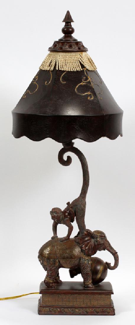 LAMP WITH ANIMAL MOTIF H 36" W 10" D 5": LAMP WITH ANIMAL MOTIF H 36" W 10" D 5" :This is a modern lamp depicting a circus act of a monkey riding an elephant. The lamp is composition with a faux leather shade. Circa late 20th to early 21st c