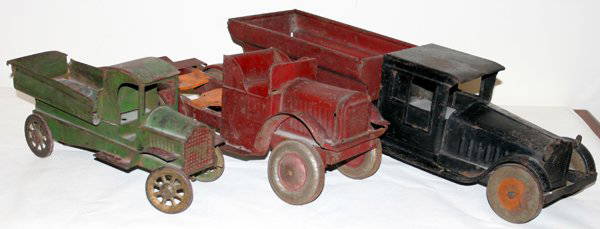 TOY METAL TRUCKS, THREE: TOY METAL TRUCKS, THREE:Including 1 Kiddies Metal Toys Inc. truck, L 19" (lacking parts); 1painted black and red metal dump truck, L 23 1/2", unmarked (as is condition); and 1 other.