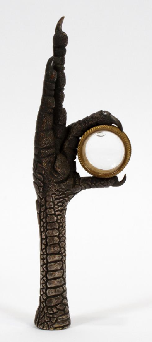 GOTHIC BRONZE MAGNIFYING GLASS W 2" L 6": GOTHIC BRONZE MAGNIFYING GLASS W 2" L 6" Gothic magnifying glass in the form of an eagle claw clutching the lens. Measuring just under 6" H. and just under 2" W.