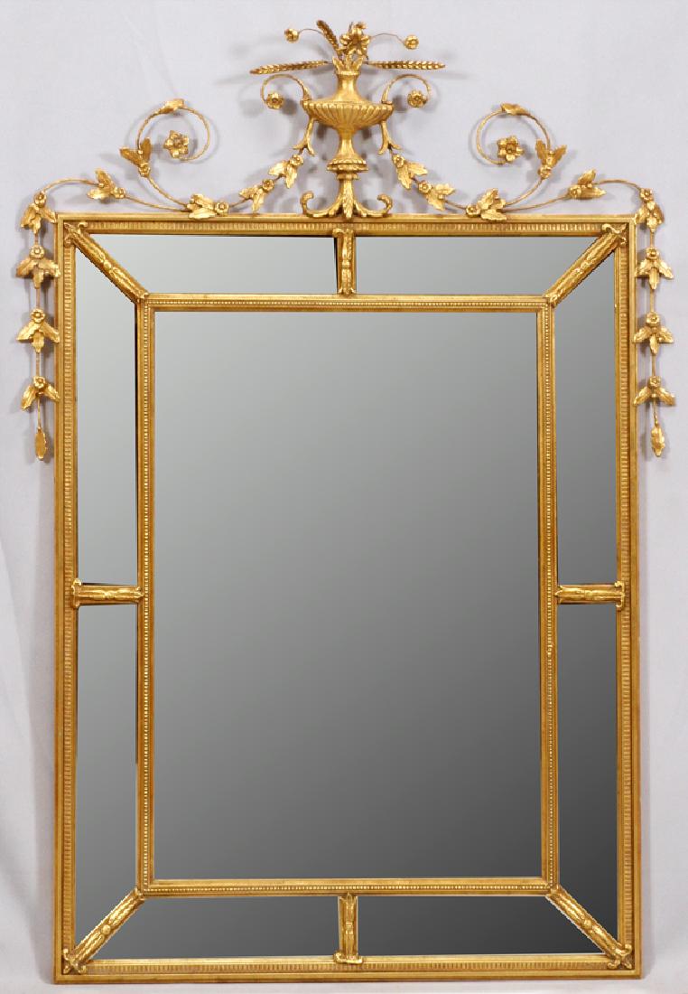BAKER FURNITURE GILT WOOD & GESSO MIRROR: BAKER FURNITURE GILT WOOD & GESSO MIRROR, H 64'', W 43'' Baker Furniture Co. "Antique Reproduction" gilt wood and gesso cushion mirror with a trophy crest and hanging garland ornament. H 64'', W 43''.