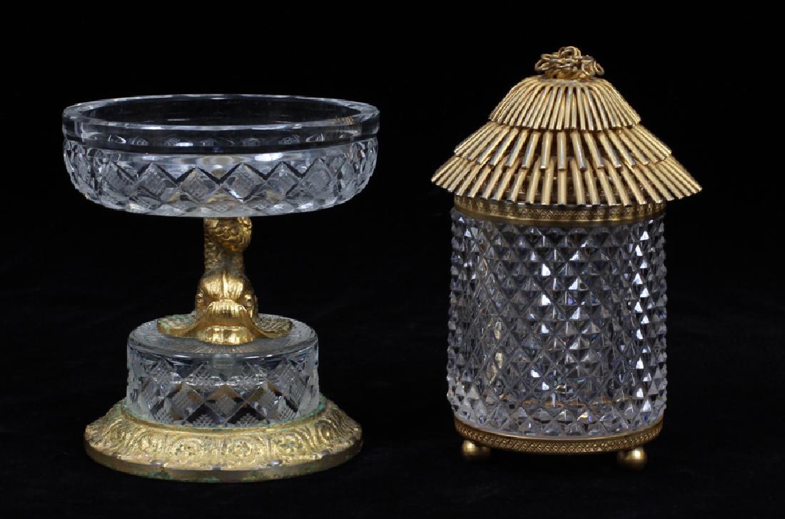CRYSTAL & BRONZE DRESSER DECORATIONS, 2 PCS: CRYSTAL & BRONZE DRESSER DECORATIONS, 2 PCS :Dolphin form compote with crystal basin and a hinged covered box with a hut style lid. Compote height 4 1/2". Box height 5 1/4".