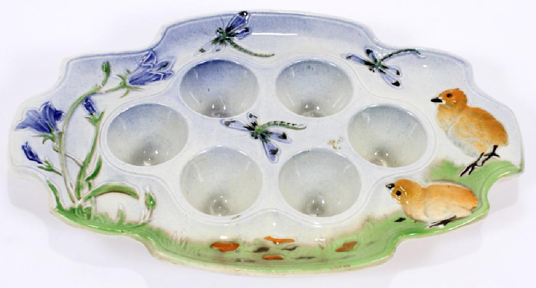 FRENCH CERAMIC EGG TRAY, 20TH C.: FRENCH CERAMIC EGG TRAY, 20TH C., H 1.5", W 10.75", D 6.75":A stoneware egg tray. Depicting chicks, dragonflies and flowers and six egg cups. Having "St. Clement" and "Made in France" stamped to the u