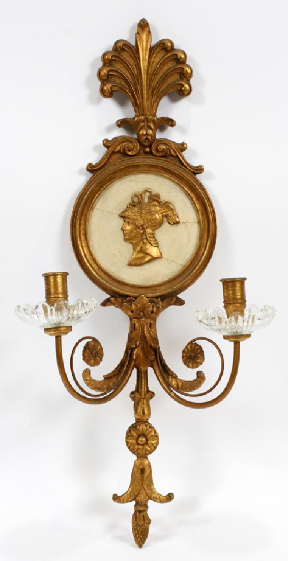 GILT WOOD & GLASS 2 LIGHT SCONCE, H 22", L 11": GILT WOOD & GLASS 2 LIGHT SCONCE, H 22", L 11" :Not electrified. Carved and gilt wood featuring plumed crest, scrolling arms, floral motifs, and crystal bobeches. Central medallion features a gilded b