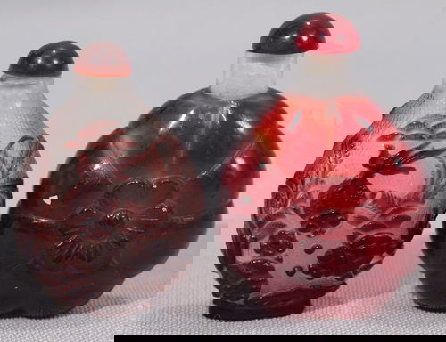 CHINESE CARVED RED AND BROWN PEKING GLASS SNUFF B: CHINESE CARVED RED AND BROWN PEKING GLASS SNUFF BOTTLES, 2, H 2 3/4", 2 1/2" Red bottle having a ribbed design with a central flower; brown having aquatic fish design carved to crosshatched clear.