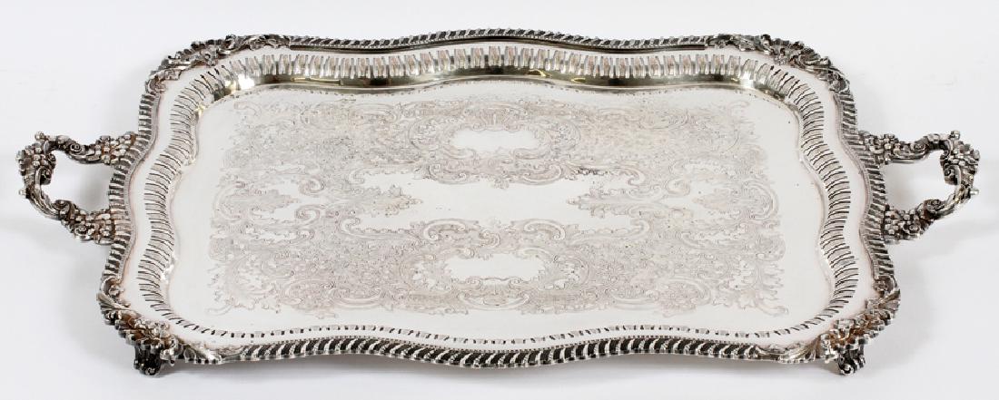 ROCOCO INFLUENCE SILVER PLATE BUTLER: ROCOCO INFLUENCE SILVER PLATE BUTLER'S TRAY W 19" L 30" :A shell and scroll motif Rococo influence butler's tray. Having grape motif handles, a pierced rim and four feet. Actual measurements are 19" w