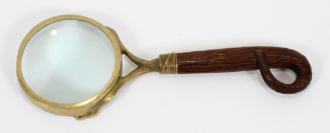 BRASS MAGNIFYING GLASS, H 14.5", W 5.5", D 1": BRASS MAGNIFYING GLASS, H 14.5", W 5.5", D 1":A magnifying glass. Having a brass frame and reeded wood handle.