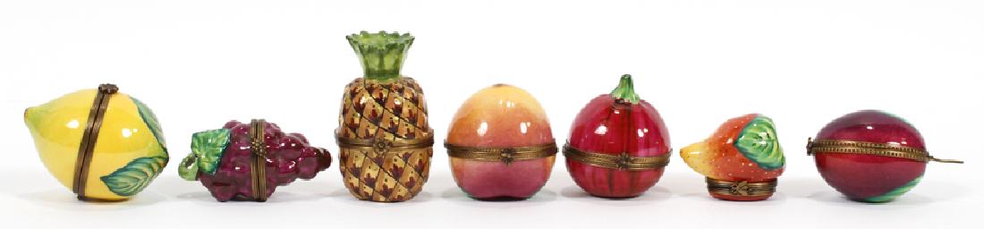 LIMOGES PORCELAIN FRUIT FORM BOXES, 7 PIECES: LIMOGES PORCELAIN FRUIT FORM BOXES, 7 PIECES H 2" - 3" :Seven Limoges fruit form boxes: 1 Grape bunch, L 3"; 1 Pineapple, H 3"; 1 Plum, H 2.5"; 1 Apple, H 2"; 1 Pomagranite L 2.5"; 1 Lemon H 3" and 1