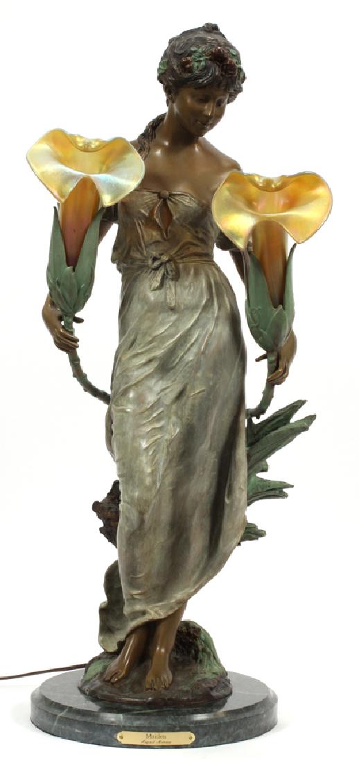 AFTER AUGUSTE MOREAU BRONZE SCULPTURE LAMP: AFTER AUGUSTE MOREAU BRONZE SCULPTURE LAMP H 28" W 12" :An electrified bronze sculptural lamp depicting an allegorical woman holding two flowers. The flower form lampshades are art glass. After August