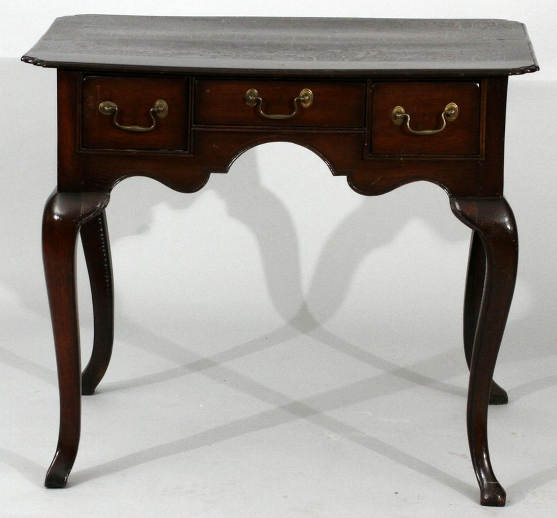 ENGLISH WALNUT LOWBOY H 28", W 33", D 21": ENGLISH WALNUT LOWBOY H 28", W 33", D 21":A walnut table that features three drawers with brass pull handles. The beveled-edged surface and scalloped trim is complimented by the table's cabriole legs.
