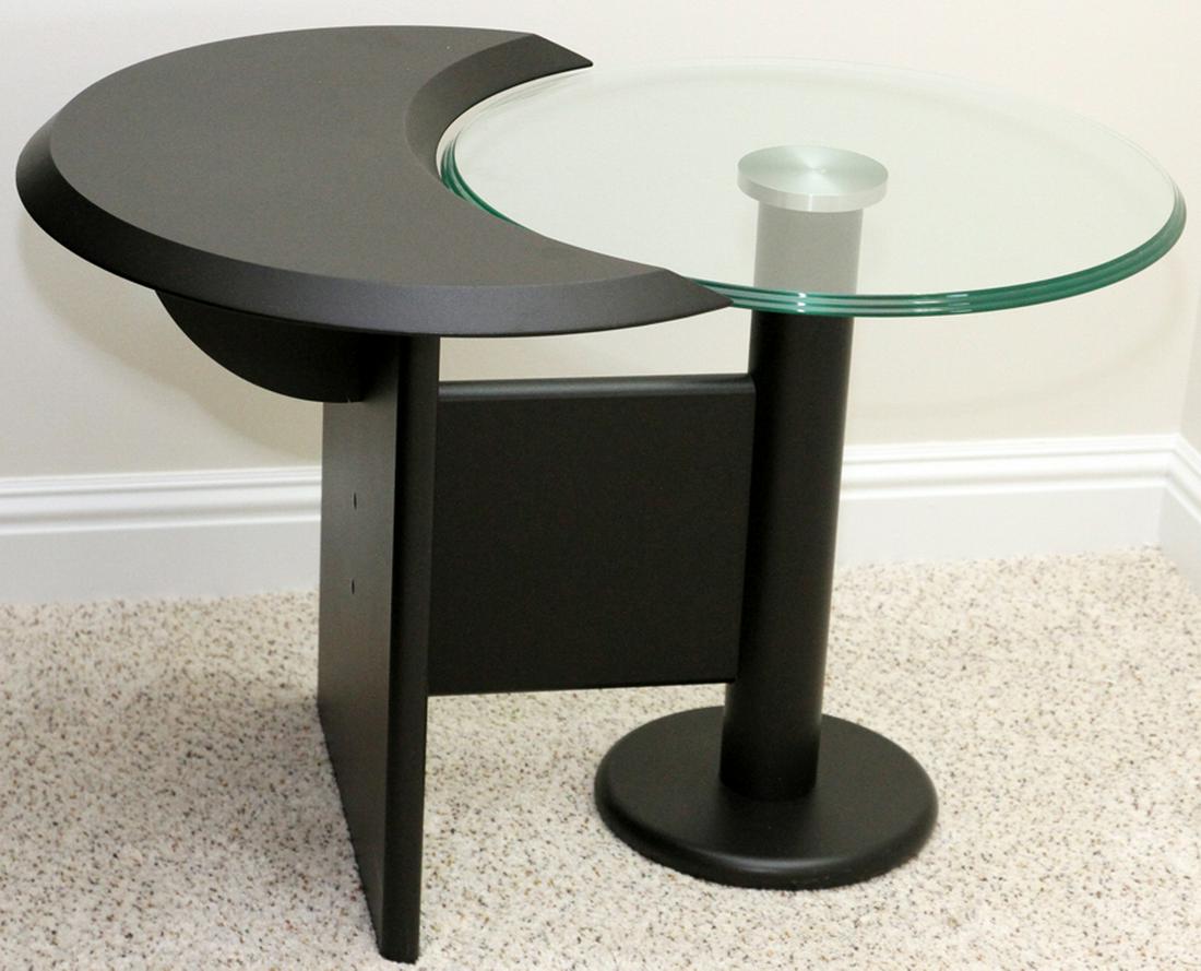 MODERN GLASS AND BLACK DECORATED SIDE TABLE: MODERN GLASS AND BLACK DECORATED SIDE TABLE, LATE 20TH C., H 20", W 23 3/8", L 30 1/4":Having a black finish with a round glass top mounted on a pedestal integral to the table. No apparent labels.