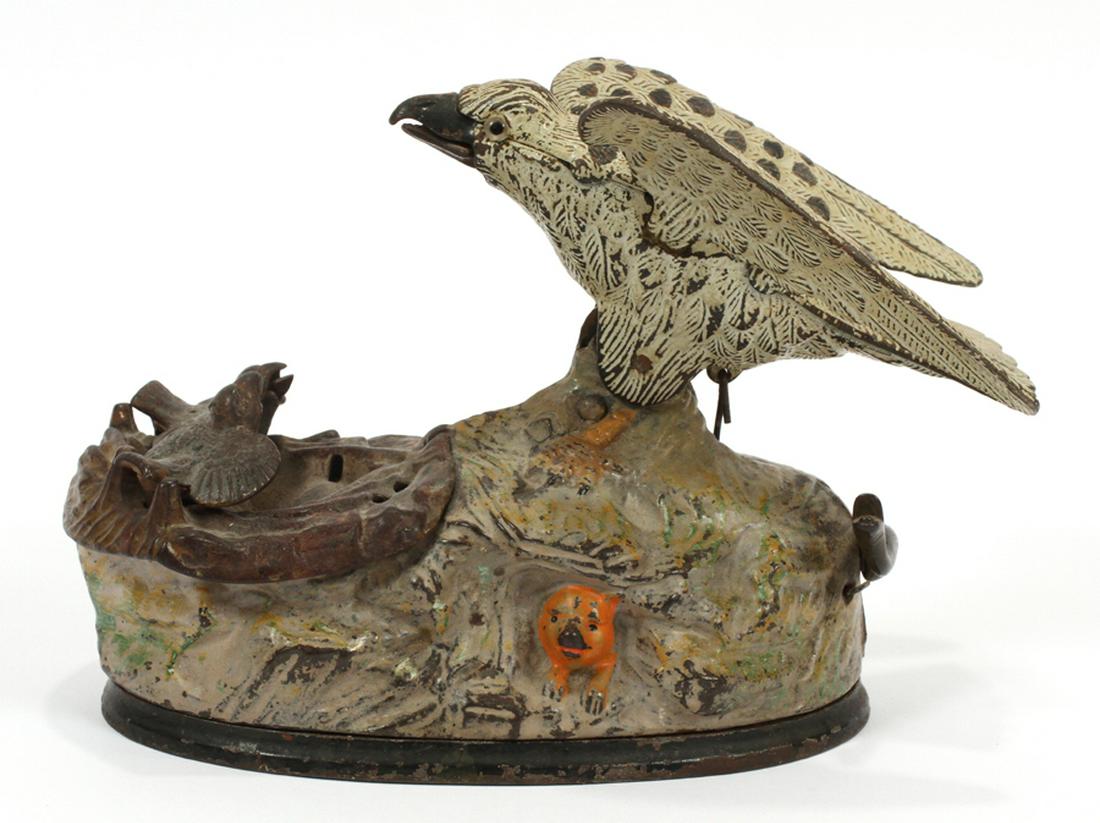 J & E STEVENS AMERICAN CAST IRON BANK: J & E STEVENS AMERICAN 'EAGLE AND EAGLETS' CAST IRON BANK, C. 1883, H 6", DIA 9" :A cast-iron mechanical bank by the J & E Stevens company. The mechanical action allows the mother bird to feed her chi