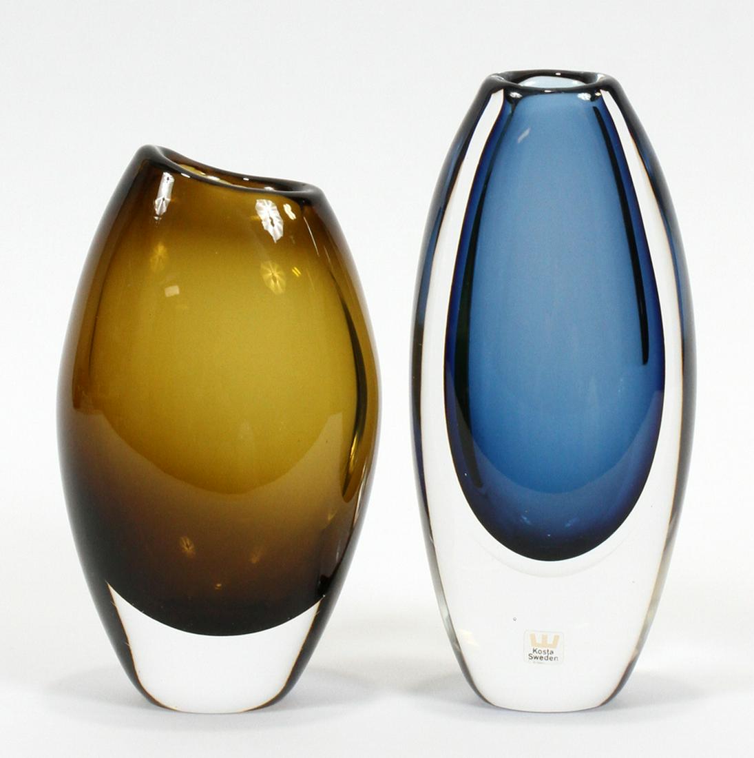 VICKE LINDSTRAND FOR KOSTA MODERNIST GLASS VASES: VICKE LINDSTRAND FOR KOSTA (SWEDEN, 1904-1983) MODERNIST GLASS VASES, H 7", 8" :Two art glass vases by Kosta of Sweden. Clear cased glass over blue and gold glass. The gold vase is by Vicke Lindstrand