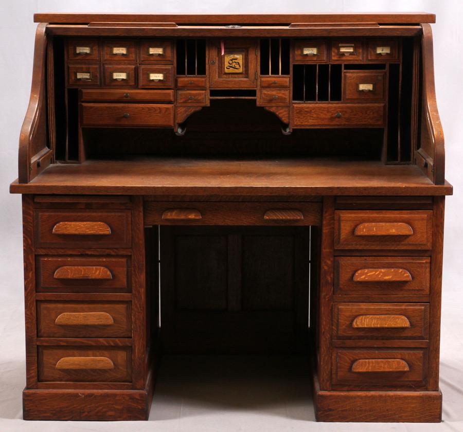 ROLLTOP OAK DESK, C1900, H 51", W 52", D 34": ROLLTOP OAK DESK, C1900, H 51", W 52", D 34" An oak rolltop desk. Having 17 top drawers and two pen slides with 9 lower drawers. Actual measurements are 50.5" tall by 52" wide by 34" deep.