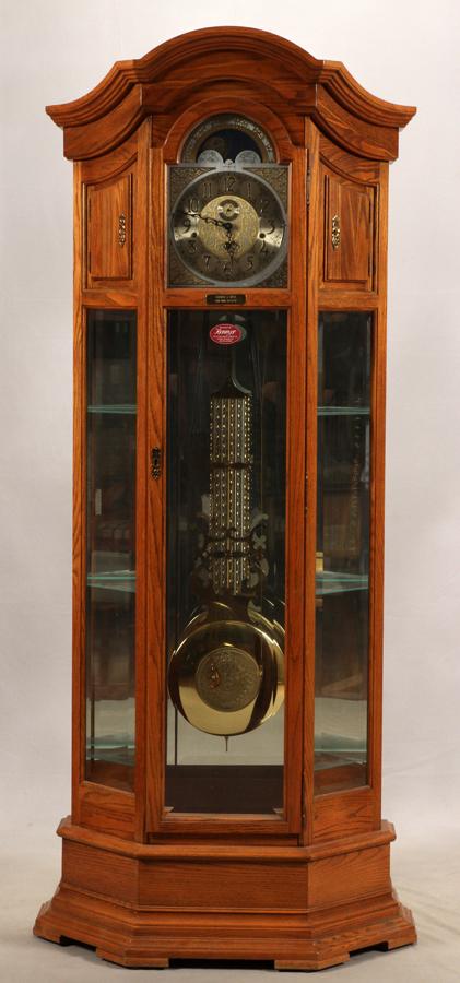 HOWARD MILLER GRANDFATHER CLOCK & DISPLAY CABINET: HOWARD MILLER, COMBINATION GRANDFATHER CLOCK AND DISPLAY CABINET, C1997, H 82", W 28", D 14" Howard Miller Majestic II Curio Grandfather Clock. Model 610-440. Having an arched pediment. A special cast