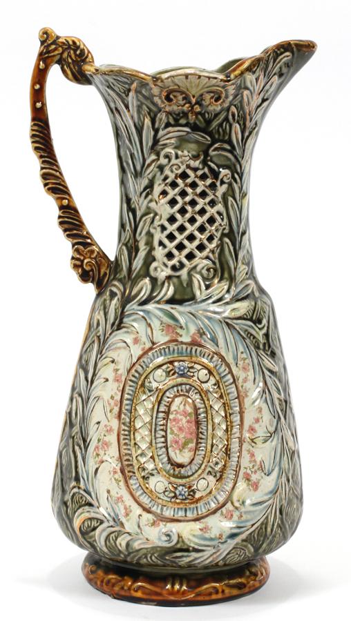 MAJOLICA POTTERY GREEN/BROWN PITCHER, C. 1890: MAJOLICA POTTERY GREEN/BROWN PITCHER, C. 1890, H 13.5", D 7" #873. Floral panel. Artist monogram on base.