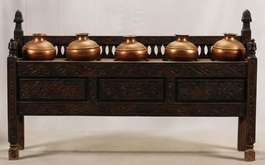 MIDDLE EASTERN CARVED WOOD BUFFET WITH COPPER POTS: MIDDLE EASTERN CARVED WOOD BUFFET WITH COPPER POTS, H 48", L 79", D 18" From Afghanistan or Pakistan. Antique carved scroll work. Pierced backlash openings for 5 copper water pots (each H 9" Dia 11").