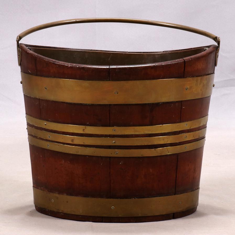 LATE GEORGE III BRASS-BOUND MAHOGANY PEAT BUCKET: LATE GEORGE III BRASS-BOUND MAHOGANY PEAT BUCKET, W 16" Of navette form with lifting handle.