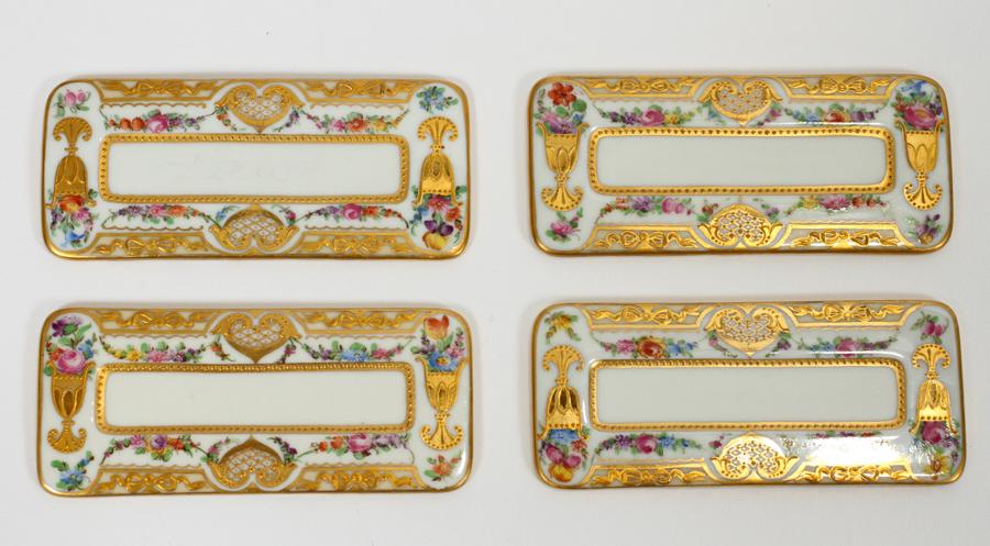 DRESDEN PORCELAIN PLACE CARD PLAQUES: DRESDEN PORCELAIN PLACE CARD PLAQUES, 15, L 4" A set of 15 handpainted Dresden porcelain place setting plaques, having a floral motif accented with raised gilt accents. All having a blue lamb mark wit