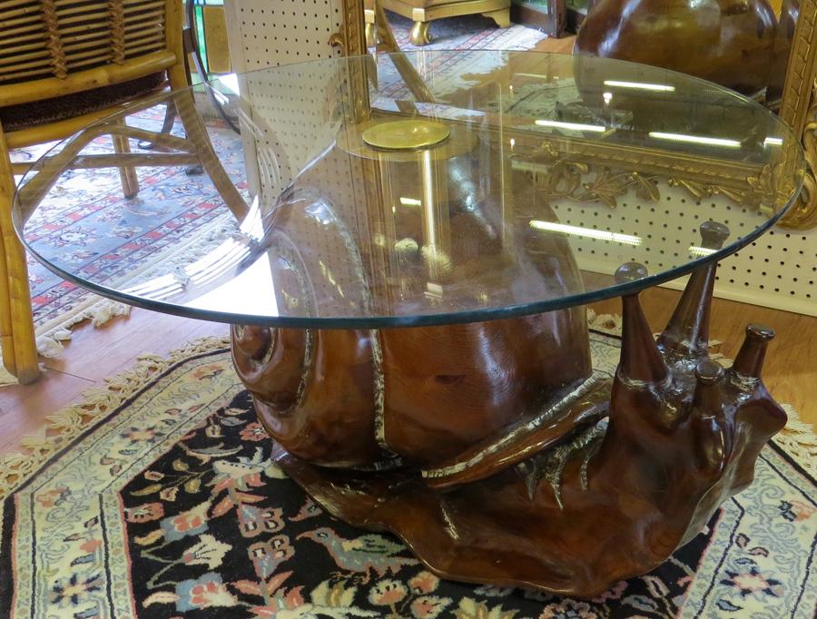 FEDERICO ARMIJO SNAIL FORM WOOD & GLASS TABLE: FEDERICO ARMIJO SNAIL FORM WOOD & GLASS TABLE H 17" DIA 32" Having a carved wooden base in the form of a snail with a round glass top.