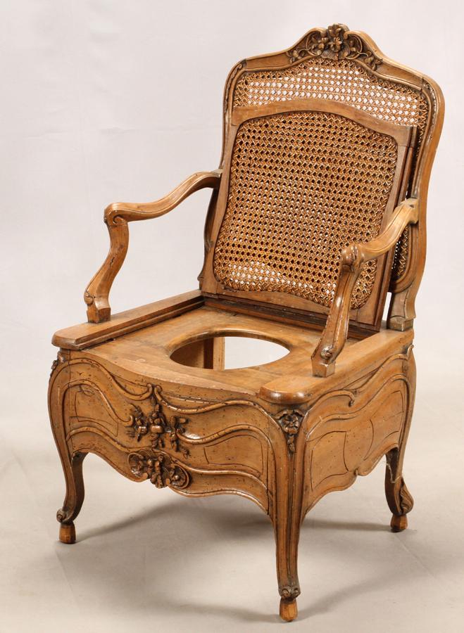 FRENCH, CARVED WALNUT AND CANE COMMODE, CHAIR: FRENCH, CARVED WALNUT AND CANE COMMODE, CHAIR, H 40", L 24" Having an elaborately hand-carved frame with a caned back and seat which lifts. Depth 19.5".