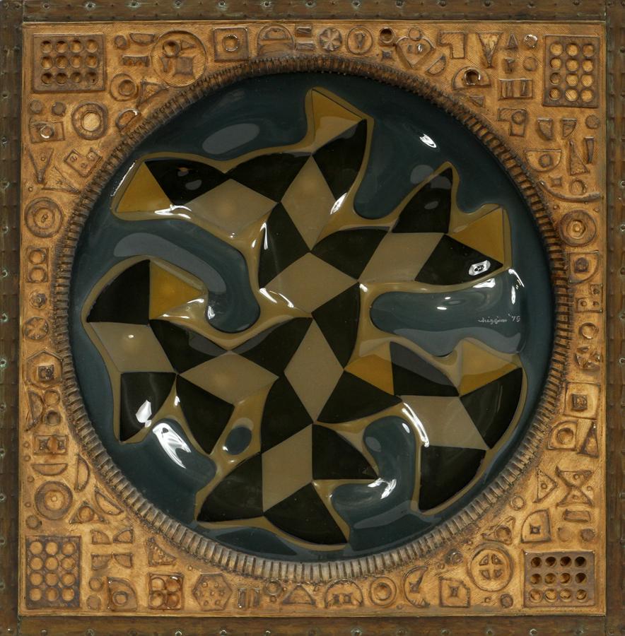 MICHAEL HIGGINS FUSED GLASS WALL MOUNTING: MICHAEL HIGGINS (AMER, 20TH C), FUSED GLASS WALL MOUNTING, H 11", ROUNDEL A roundel in blue-black, shades of olive and gray blue-green glass, set in gilded and textured plaster of Paris and a brass ou