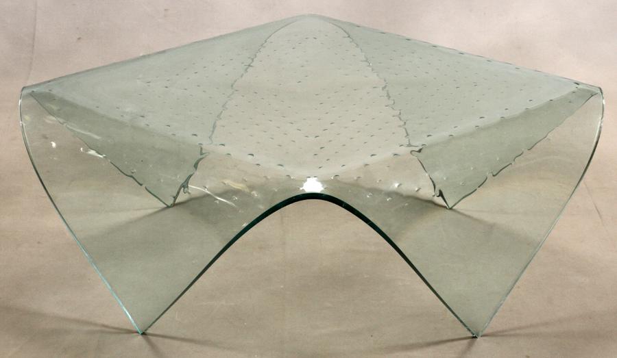 LAUREL FYFE (AMERICAN, 1956-2011) MODERNIST GLASS TABLE: LAUREL FYFE (AMERICAN, 1956-2011) MODERNIST GLASS TABLE H 16.5" W 39" L 39" A modernist free form glass table having a pattern of bubbles under the surface. The corners are bent down to form the legs.
