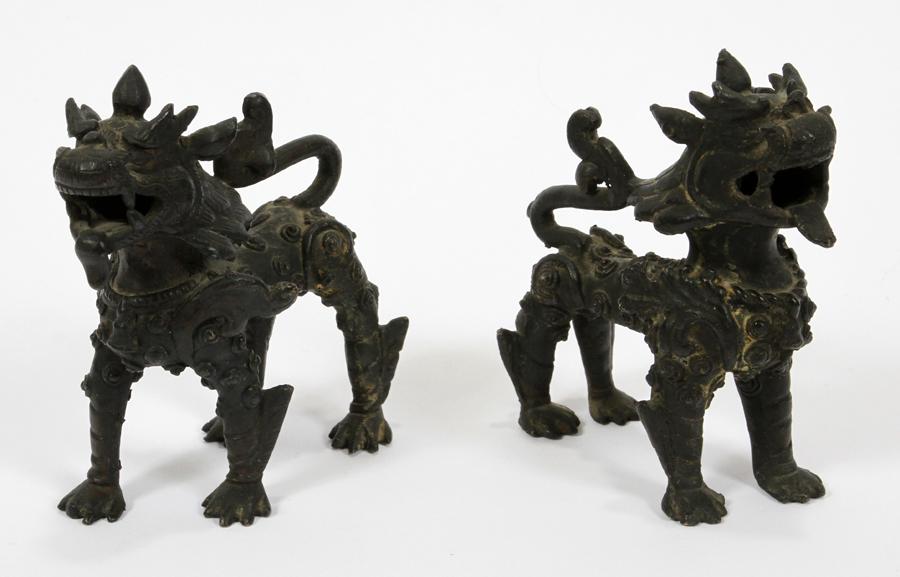 TIBETAN, BRONZE HORNED FOO-DOGS, PAIR: TIBETAN, BRONZE HORNED FOO-DOGS, PAIR, H 4 1/2", L 4", D 2" adorned in armor, dark patina finish.