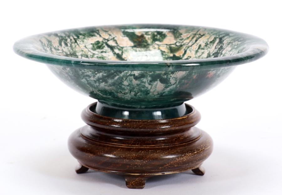 MOSS AGATE BOWL WITH STAND, H 1.25" DIA 4.5": MOSS AGATE BOWL WITH STAND, H 1.25" DIA 4.5" The Moss Agate bowl has a translucent ground with delicate green dendritic inclusions that have the appearance moss. The bowl has a wooden stand. The bowl 