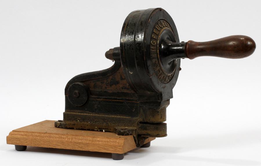 METAL MILLINER'S HAT MACHINE C. 1900: METAL MILLINER'S HAT MACHINE C. 1900 H 11" W 18" D 6" A milliner's hat machine. Metal mounted on a wooden plaque.