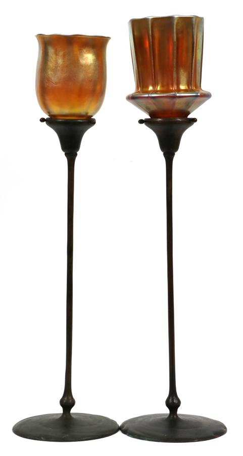 LOUIS TIFFANY & STEUBEN GLASS SHADES, BRONZE BASES: LOUIS TIFFANY & STEUBEN GLASS SHADES, BRONZE BASES, 2 PCS, H 22"A pairing of two bronze candlesticks featuring a fitted Louis Comfort Tiffany favrile shade marked "LCT" H 4.7" Dia 4" and a Steuben aur
