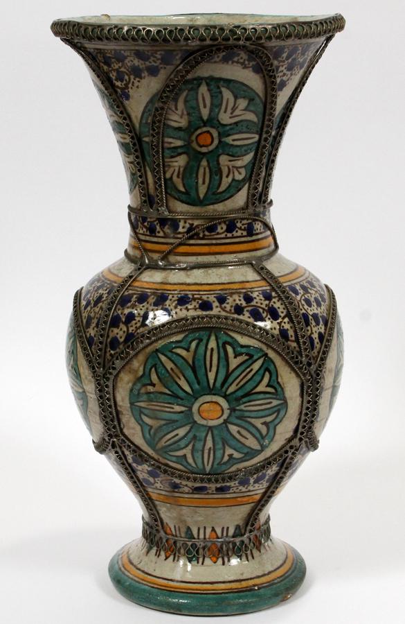 ANTIQUE MOROCCAN SILVER NICKEL, POTTERY VASE: ANTIQUE MOROCCAN SILVER NICKEL, POTTERY VASE H 14" DIA 7" An antique Moroccan pottery vase, hand-painted with blue and yellow floral motifs overlaid with silver nickel filigree.