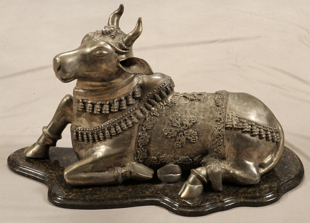 METAL SCULPTURE OF AN INDIAN BRAHMA BULL: METAL SCULPTURE OF AN INDIAN BRAHMA BULL, H 22", W 14", L 35" Depicts a reclining Brahman bull adorned in tassels, on a granite base.