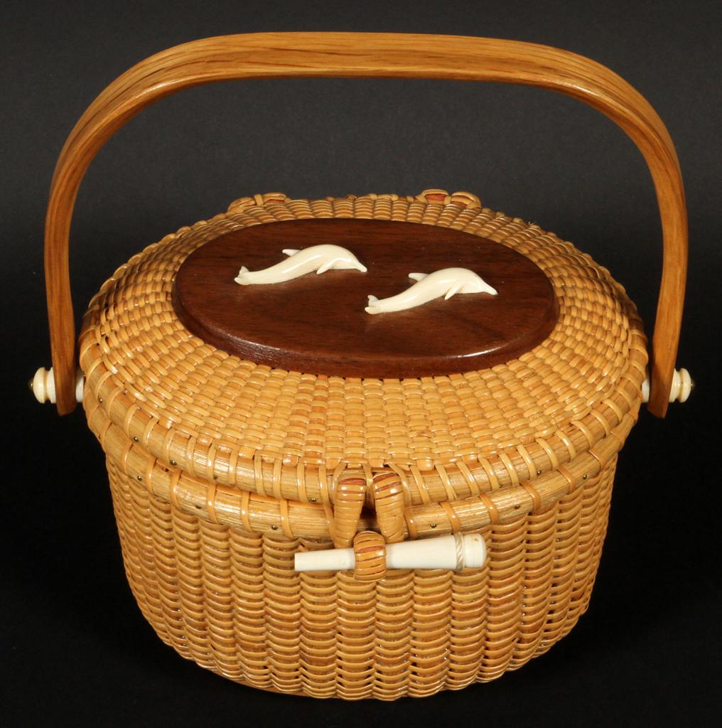 M. KANE, NANTUCKET BASKET PURSE H 9" W 6" L 7.5": M. KANE, NANTUCKET BASKET PURSE H 9" W 6" L 7.5" Having a dolphin motif at the top. The height from base to the top of the handle is 9". The height of the basket and lid alone is 4.5".