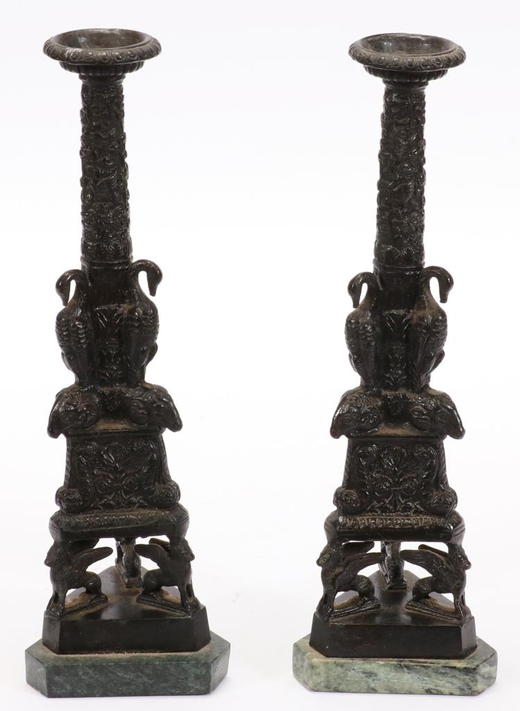 BRONZE CANDLESTICKS, PAIR, H 14", DIA 4": BRONZE CANDLESTICKS, PAIR, H 14", DIA 4"A pair of bronze candlesticks. Each in column form with ram heads and pelicans, winged lions at base presented on a marble base. Property of Robert Schweizer, A